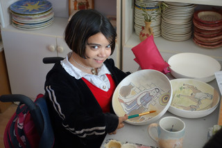 Schülerin beim Bemalen von Keramik