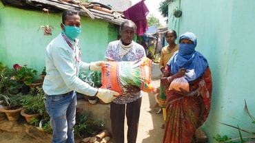 Mitarbeiter des YMCA Ranchi (Indien) verteilen Lebensmittel an Familien